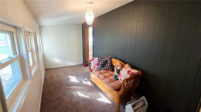 bedroom featuring a textured ceiling, lofted ceiling, wood walls, and carpet flooring