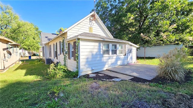 exterior space featuring a yard, cooling unit, and a patio area