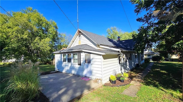 view of side of home featuring a patio and a yard