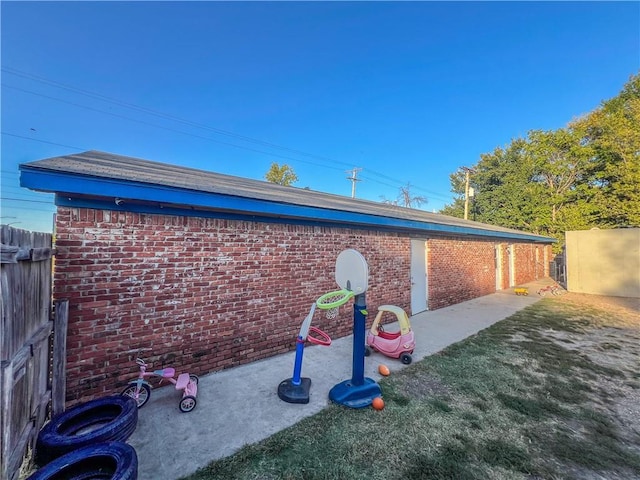 1201 S Willow St, Coffeyville, KS 67337 - view of side of home featuring brick siding and a patio