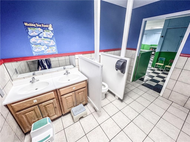 bathroom with tile walls, tile patterned flooring, vanity, and toilet