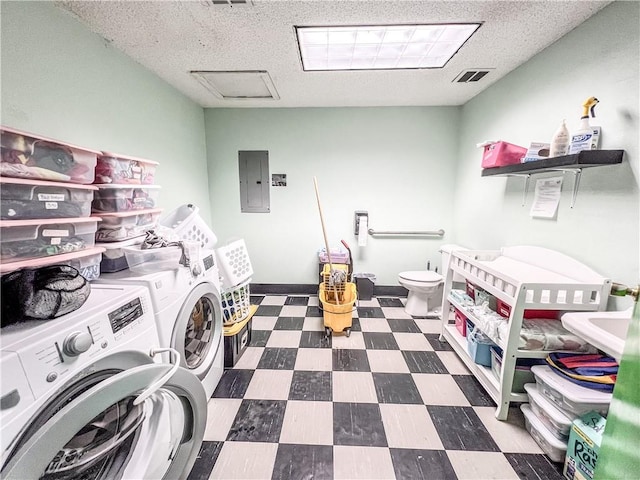 clothes washing area featuring separate washer and dryer, electric panel, and a textured ceiling