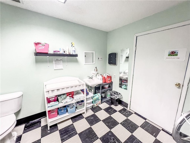 bathroom featuring a textured ceiling and toilet