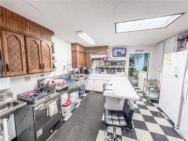 kitchen featuring a textured ceiling, a breakfast bar area, and white refrigerator