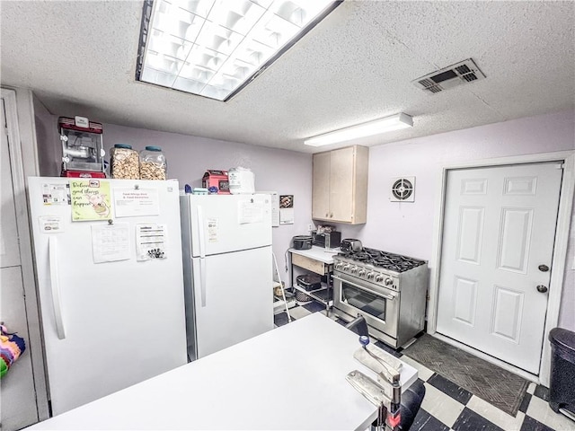 kitchen featuring high end stainless steel range, a textured ceiling, and white fridge