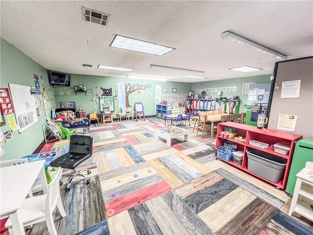 rec room featuring a textured ceiling and hardwood / wood-style floors