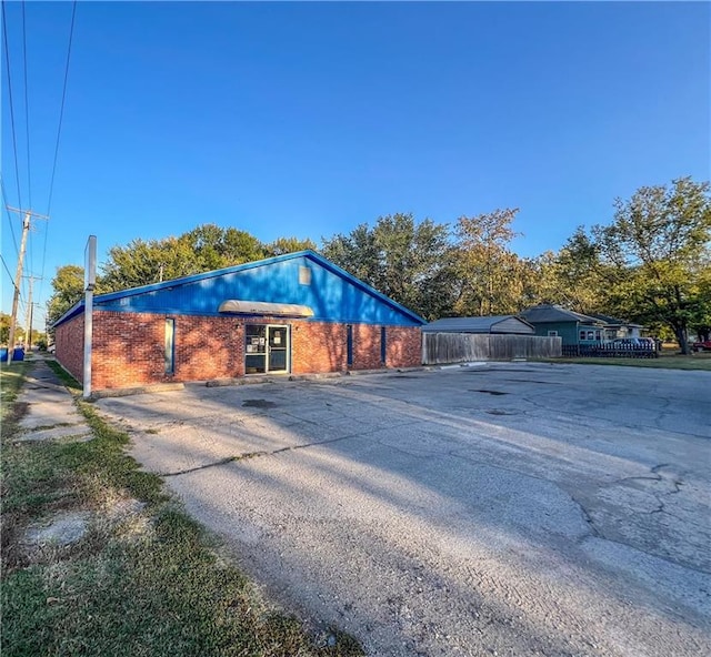 1201 S Willow St, Coffeyville, KS 67337 - view of side of home with brick siding and driveway