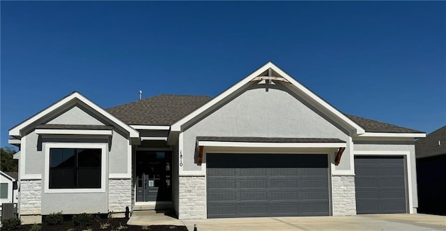 view of front of house featuring an attached garage, stone siding, and stucco siding