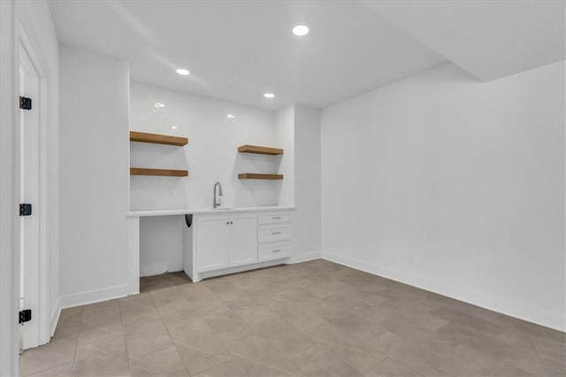 unfurnished office with recessed lighting, baseboards, and a sink