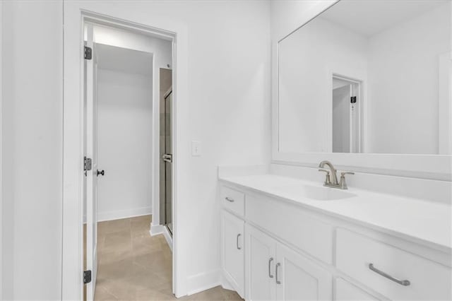 bathroom featuring tile patterned floors, a shower stall, vanity, and baseboards