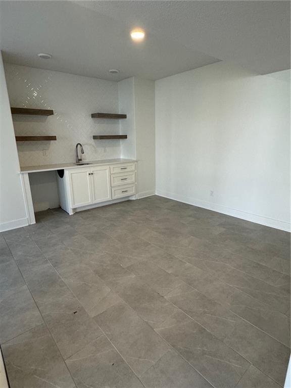 interior space with white cabinets and sink