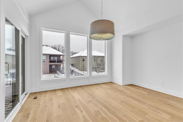 empty room featuring visible vents, high vaulted ceiling, baseboards, and wood finished floors