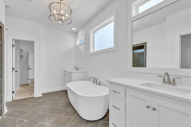 full bathroom featuring a sink, a notable chandelier, a freestanding bath, and tile patterned flooring