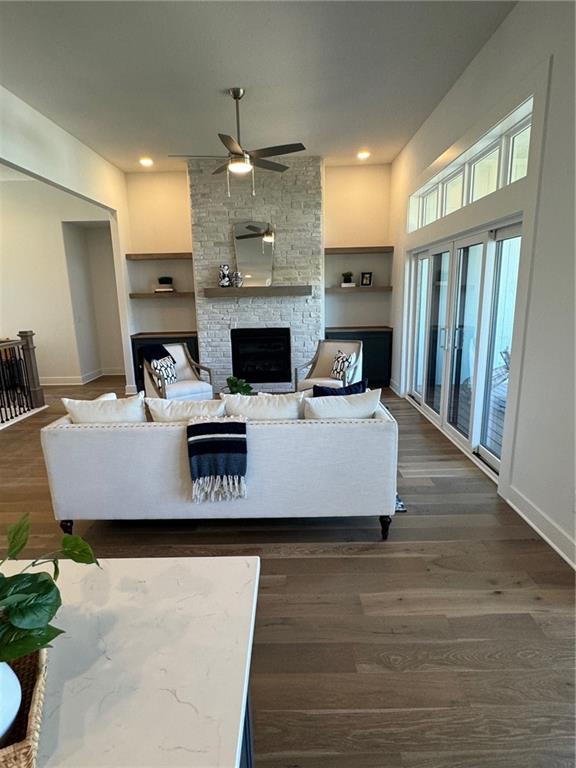 living room with baseboards, dark wood finished floors, recessed lighting, a fireplace, and ceiling fan