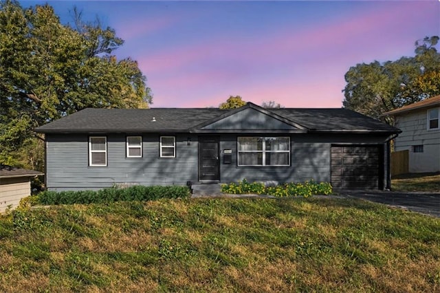 single story home featuring a yard and a garage