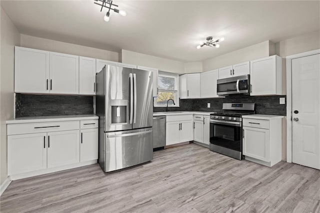 kitchen featuring sink, white cabinets, light hardwood / wood-style flooring, and stainless steel appliances