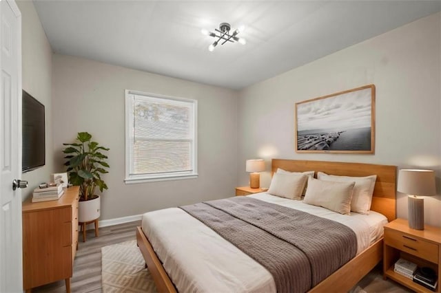 bedroom with a notable chandelier and hardwood / wood-style floors