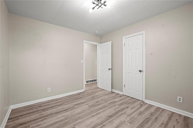 unfurnished bedroom featuring light hardwood / wood-style floors and a closet