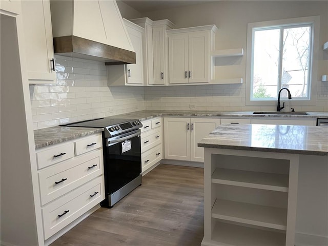 kitchen featuring custom exhaust hood, sink, stainless steel range with electric stovetop, dark wood-type flooring, and white cabinetry