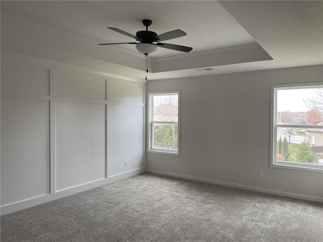 empty room featuring carpet, ceiling fan, and a wealth of natural light