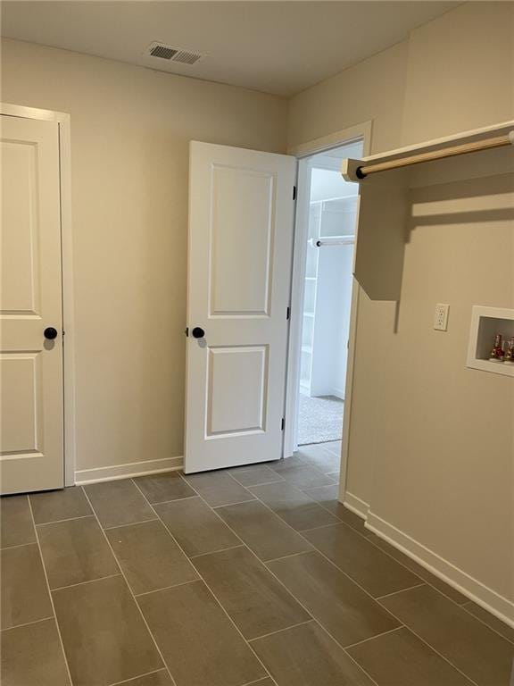 clothes washing area with washer hookup and dark tile patterned floors