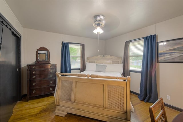 bedroom with hardwood / wood-style flooring, ceiling fan, and a closet