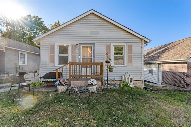 rear view of property featuring a lawn