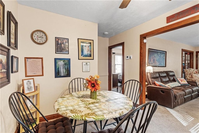 dining area with a textured ceiling and carpet floors