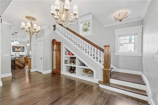 stairs with sink, crown molding, hardwood / wood-style floors, and a healthy amount of sunlight