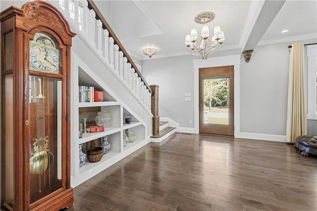 foyer entrance featuring a chandelier, dark wood-type flooring, and crown molding