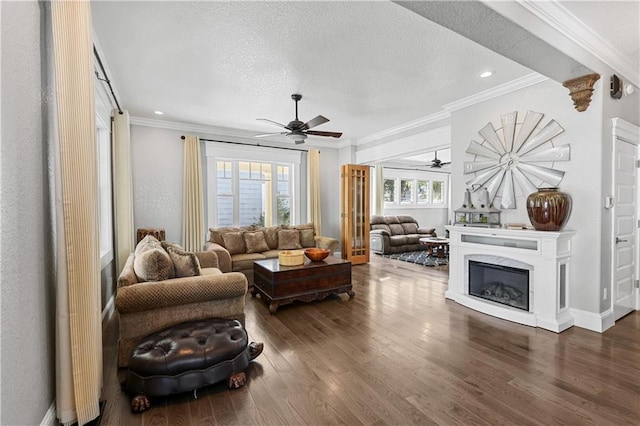 living room with ceiling fan, crown molding, dark hardwood / wood-style flooring, and a textured ceiling