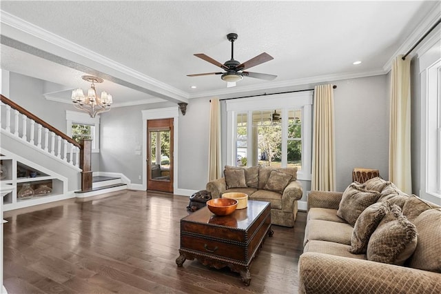 living room featuring ceiling fan with notable chandelier, ornamental molding, dark hardwood / wood-style flooring, and a textured ceiling