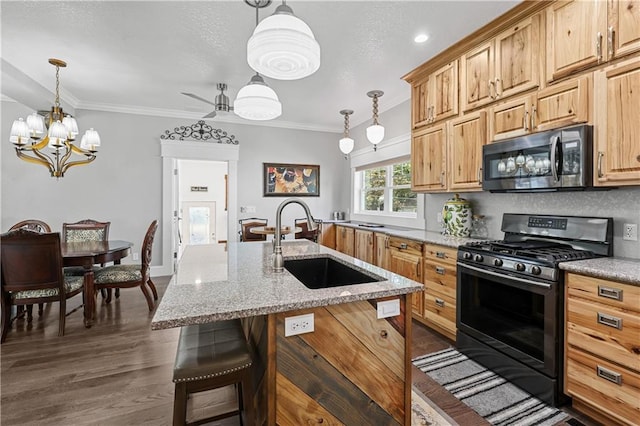 kitchen with crown molding, sink, stainless steel appliances, an island with sink, and a kitchen bar