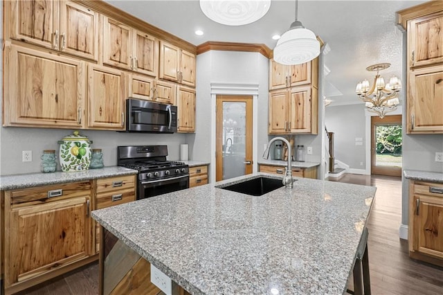 kitchen featuring pendant lighting, an island with sink, sink, appliances with stainless steel finishes, and a breakfast bar area