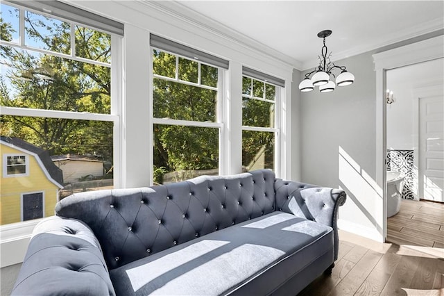 interior space with crown molding, an inviting chandelier, dark hardwood / wood-style floors, and multiple windows