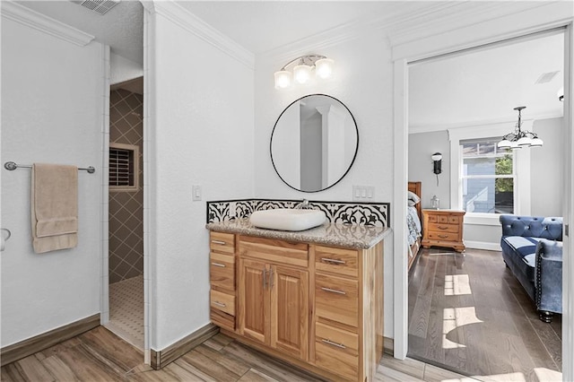 bathroom with wood-type flooring, ornamental molding, and vanity