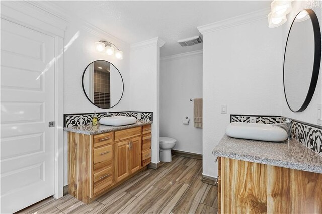 bathroom featuring vanity, crown molding, toilet, and hardwood / wood-style flooring