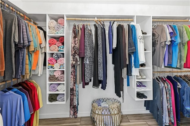 walk in closet with light hardwood / wood-style floors