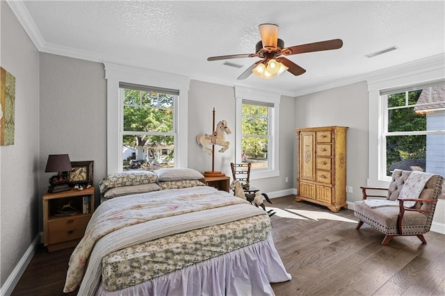 bedroom with ceiling fan, ornamental molding, a textured ceiling, and dark hardwood / wood-style flooring