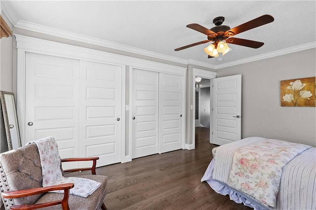 bedroom with crown molding, ceiling fan, multiple closets, and dark hardwood / wood-style floors