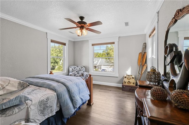 bedroom with ornamental molding, ceiling fan, dark hardwood / wood-style floors, and a textured ceiling