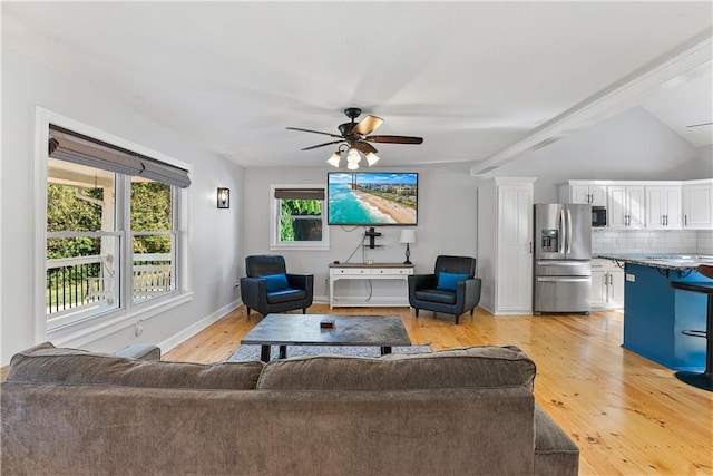 living room featuring light hardwood / wood-style floors, vaulted ceiling, and ceiling fan