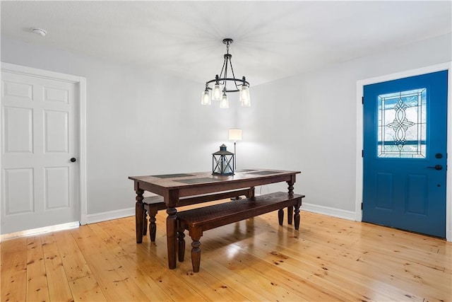 dining space featuring a notable chandelier and light hardwood / wood-style floors