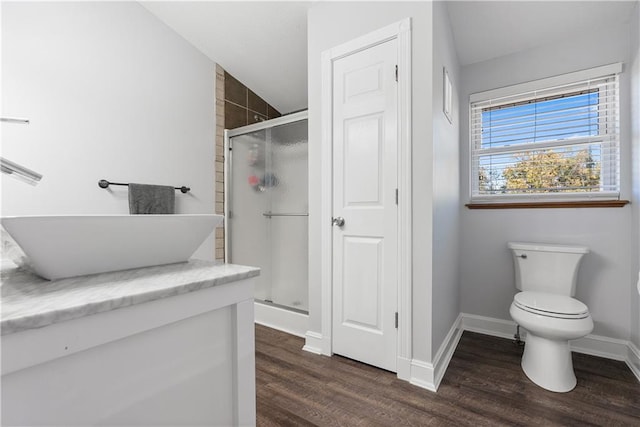 bathroom with a shower with door, hardwood / wood-style flooring, toilet, and sink