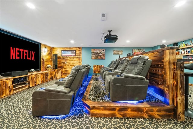 carpeted cinema room with wooden walls