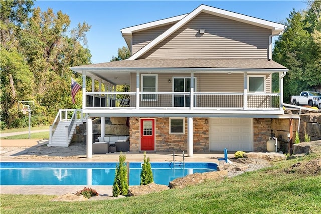 back of house with an outdoor pool, stone siding, stairs, and a patio area