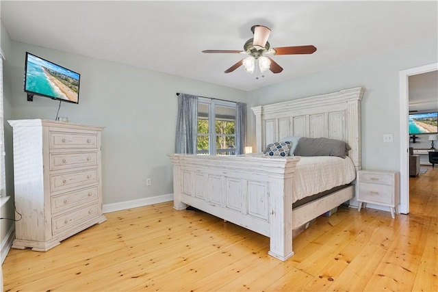 bedroom with baseboards, light wood finished floors, and ceiling fan