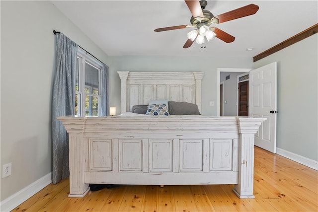 unfurnished bedroom with a ceiling fan, light wood-type flooring, and baseboards