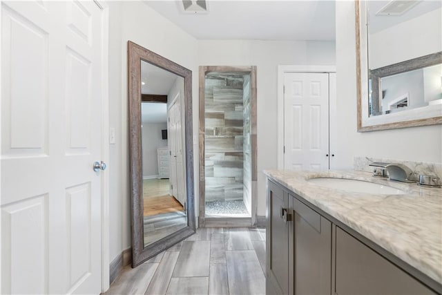 full bath with visible vents, baseboards, a stall shower, and vanity