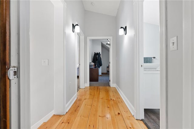 hallway featuring light wood-type flooring and baseboards